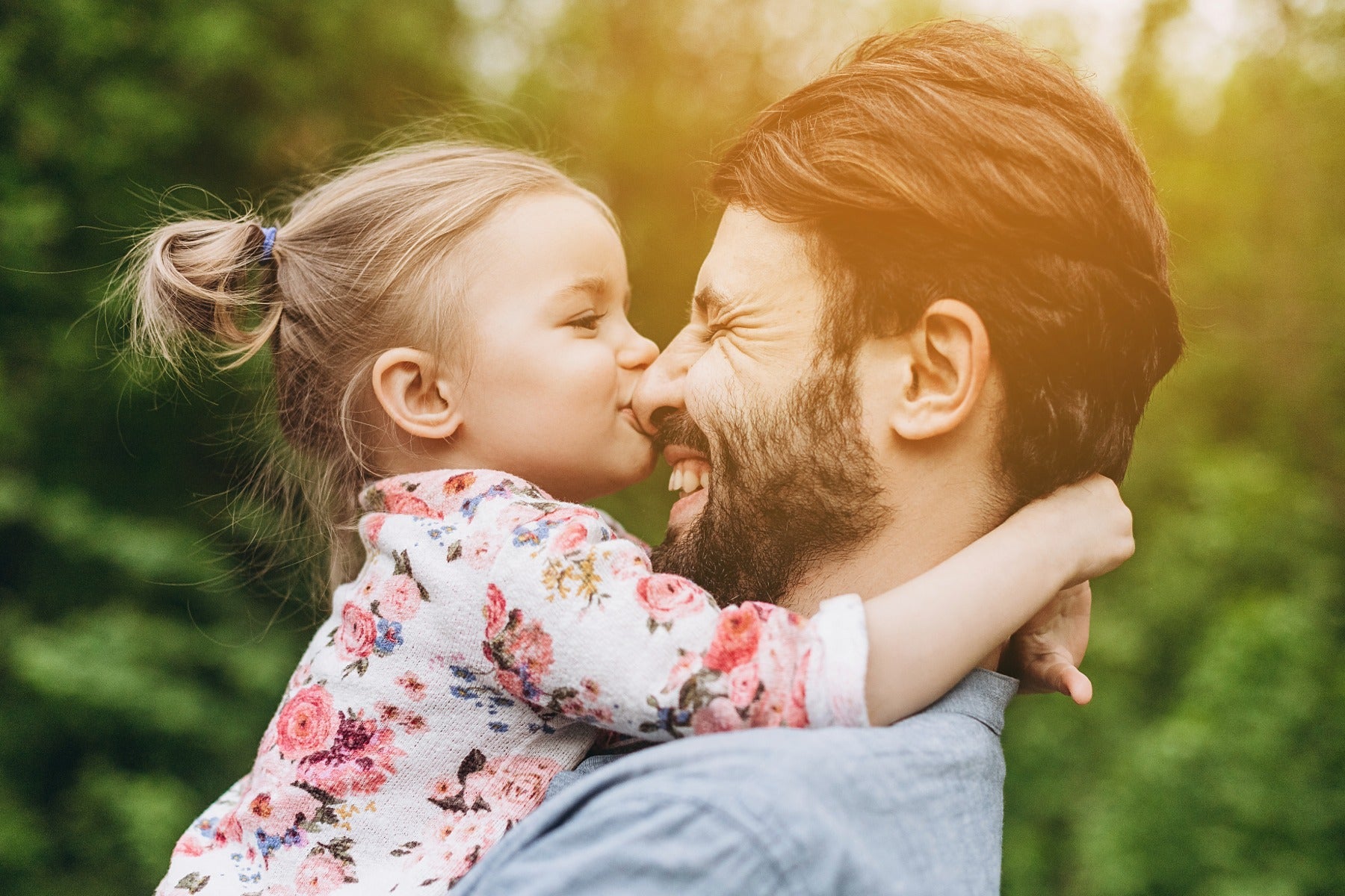 Man and young child sharing a warm outdoor moment for an online at-home paternity DNA test.