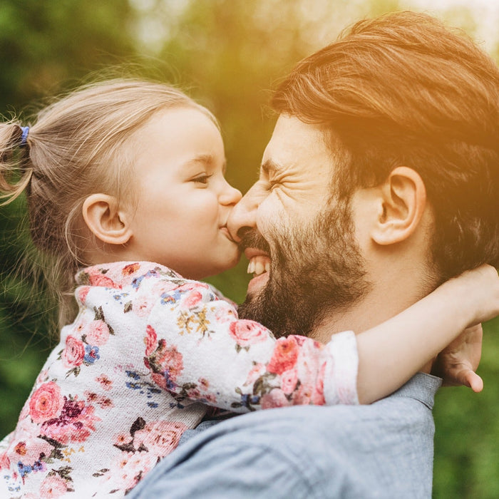 Man and young child sharing a warm outdoor moment for an online at-home paternity DNA test.
