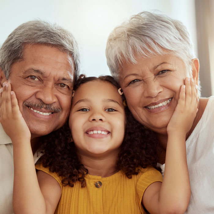 A joyful multigenerational family portrait, featuring a granddaughter with her grandparents, symbolizing the connections revealed through My Forever DNA's grandparent DNA testing.