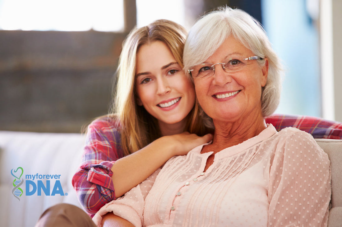 A young woman and her grandmother smiling together on a couch, with the My Forever DNA logo.