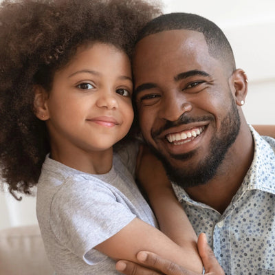 A loving father and child share a tender moment, smiling face to face. This image captures the emotional connection and reassurance that paternity testing can bring.