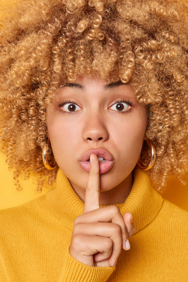 Woman signaling silence, representing private and confidential DNA testing using discreet, non-traditional samples | My Forever DNA