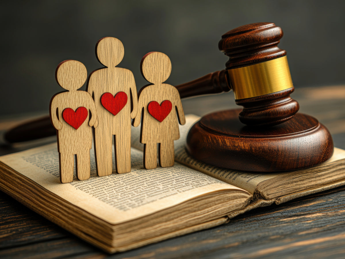 Wooden family figures with hearts beside a gavel and legal book, representing court-admissible DNA testing.