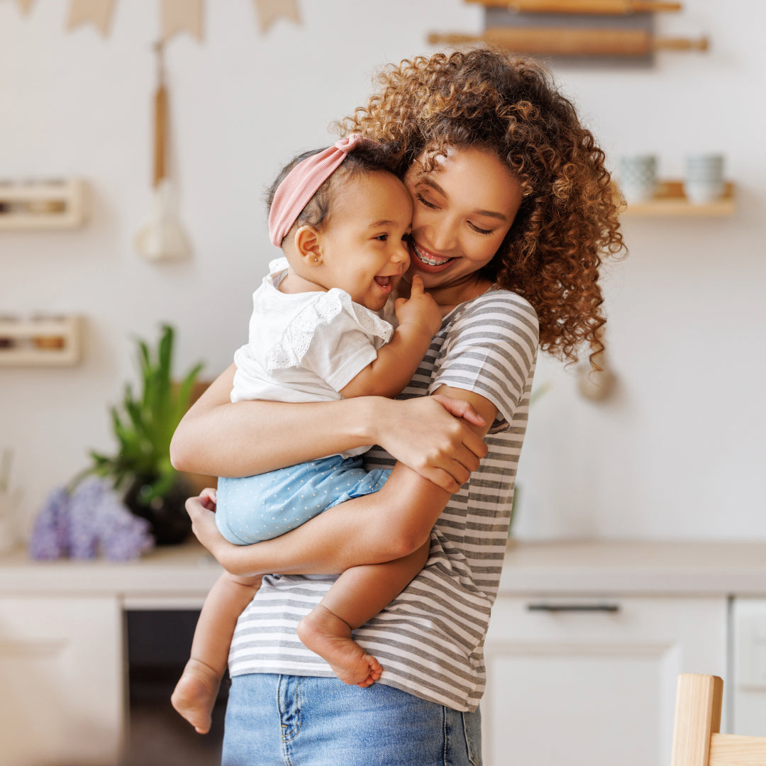 Woman holding a child in a kitchen